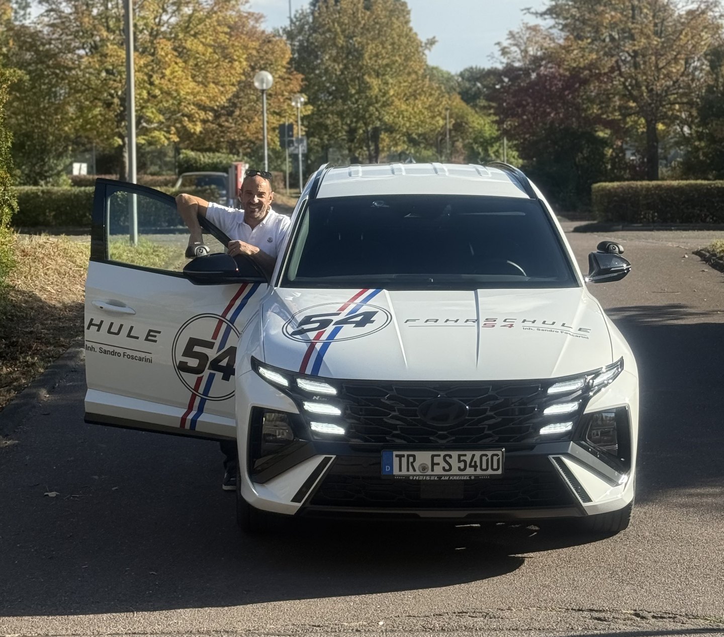 Sandro Foscarini, Inhaber der Fahrschule 54, am weißen Fahrschulauto